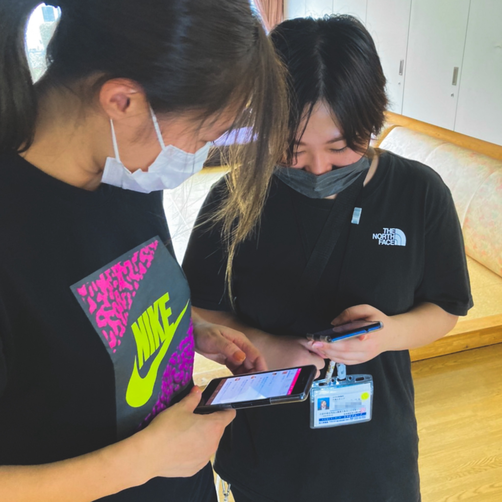 現場スタッフがスマホでケアコラボを操作する写真