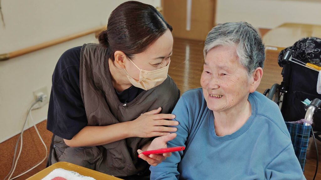 元気なうちからご利用者と会話し、その記録をスマホに入れている写真