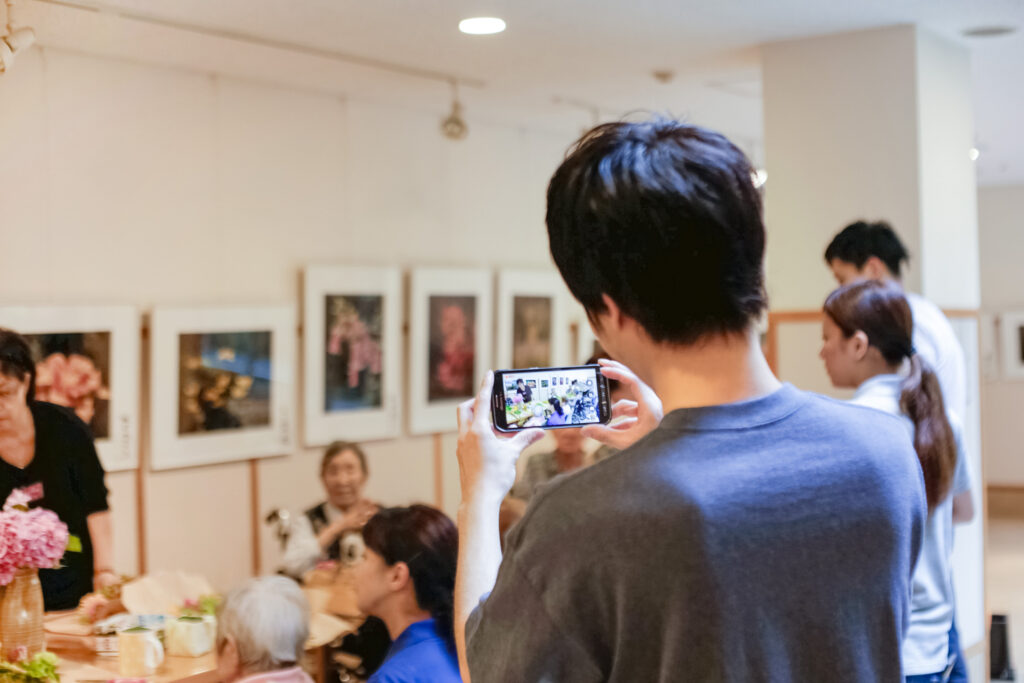 レクリエーションの実施中、スタッフが写真撮影をしている写真