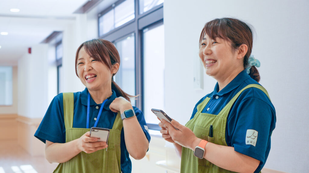 現場スタッフがスマホ端末で笑顔で記録をしている写真