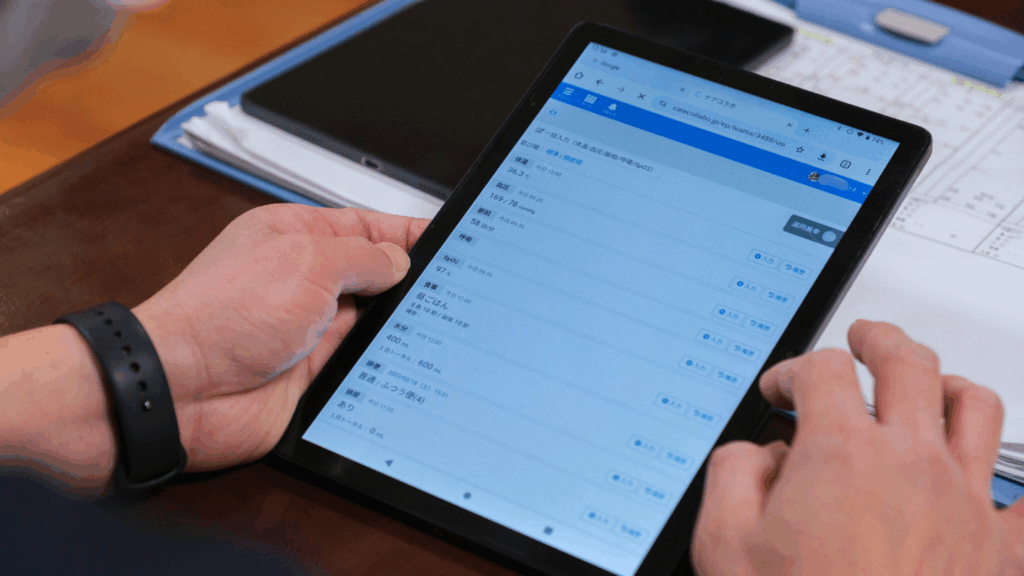 介護現場でタブレットを使ってケアコラボでバイタルを入れている写真