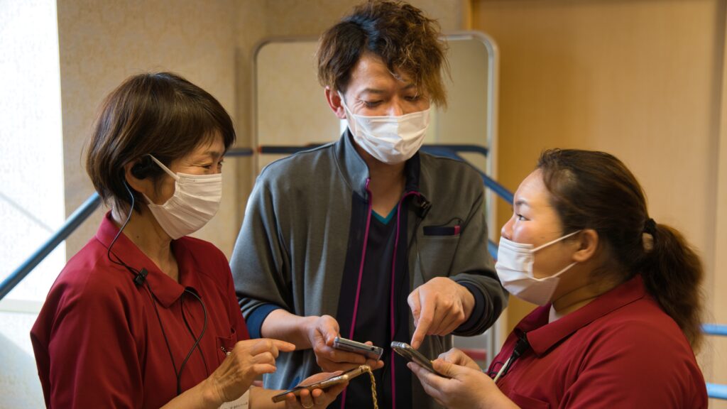 インカムをつけながら他職員と楽しそうに会話をしている写真