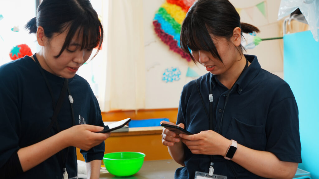 平野の里さまの新人スタッフがスマホでケアコラボを操作している様子
