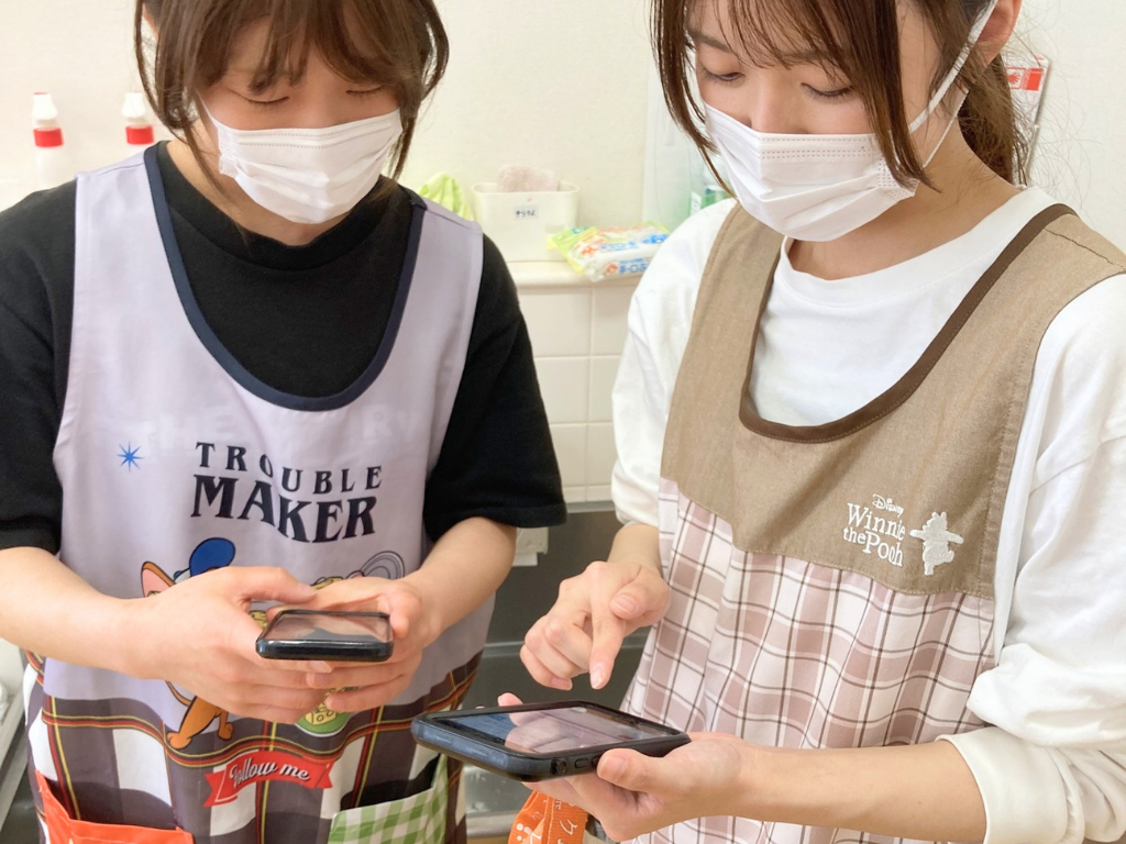 スタッフ同士でケアコラボの使い方を教え合う写真